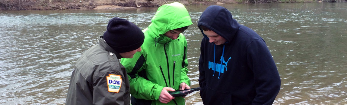 A park educator and students looks at a computer during a Watershed Education investigation, Pennsylvania State Parks.